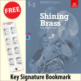 front cover of ABRSM Shining Brass Book 1 Eb Piano Accompaniment together with free Piano Clef bookmark